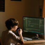 Boy in White T-shirt Sitting on Chair in Front of Computer